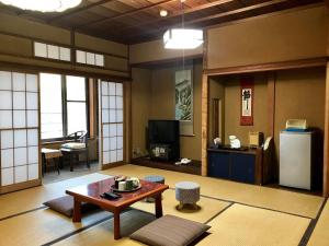 a living room with a table and a refrigerator at Tsukinoya in Hakone