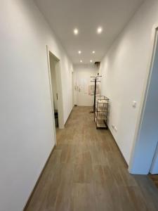 an empty hallway with white walls and wooden floors at Szenetreff City in Würzburg