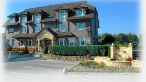 a large brown building with a landscaping in front of it at Hotel Restaurant Bergeshöhe in Mettingen +15 photos