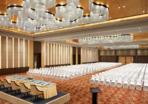 an empty banquet hall with white tables and chairs at Taj Agra in Agra