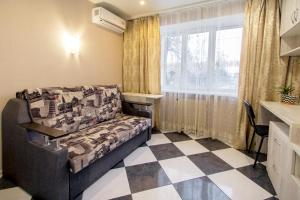 a living room with a couch and a checkered floor at Смарт-студия на Гагарина возле Бот сада in Dnipro