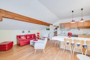 eine Küche und ein Wohnzimmer mit einem roten Sofa in der Unterkunft Alpenblick in Eggstätt
