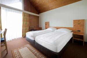 a large bedroom with two beds and a window at Hotel zur Post in Weilheim an der Teck