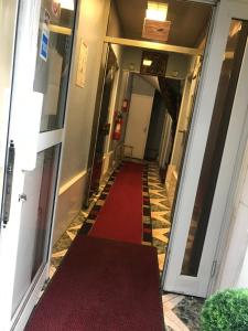 un couloir avec un tapis rouge dans un bâtiment dans l'établissement FM Hotel, à Paris