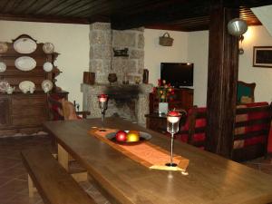sala de estar con mesa de madera y chimenea en Quinta De Cabrum, en Alvoco da Serra