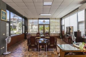a dining room with tables and chairs and large windows at YOJA B&B in Puli