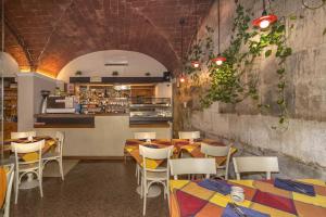 a restaurant with tables and chairs and a counter at Hotel Amalfitana in Pisa