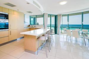 a kitchen with a table and chairs and the ocean at The Waterford on Main Beach in Gold Coast