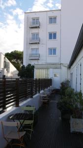 a balcony with tables and chairs and a building at Hôtel Savary in La Rochelle