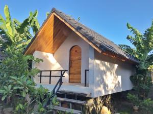 a small house with a wooden door and stairs at Phố Đá Hotel in Lagi +57 photos