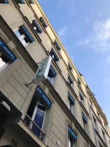 um edifício com um sinal na lateral em FM Hotel em Paris