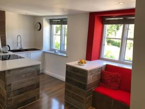 a kitchen with a red bench and a red chair at Old Fleece Apartments in Stroud