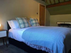 1 dormitorio con 1 cama blanca grande con almohadas en Old Fleece Apartments, en Stroud