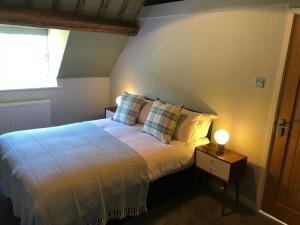 een slaapkamer met een bed en een lamp op een tafel bij Old Fleece Apartments in Stroud