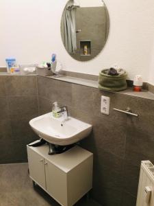 a bathroom with a sink and a mirror at Ferienwohnung Susanna in Friedrichshafen +13 photos