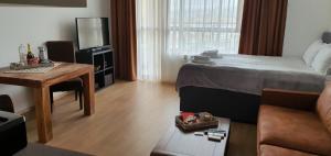 a bedroom with a bed and a table and a television at Студио Тони in Varna City