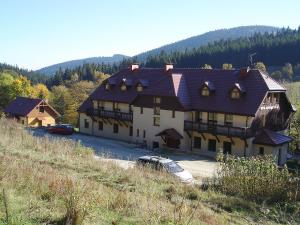 a large house with a car parked in front of it at Domek Górski Sienna- Czarna Góra in Sienna