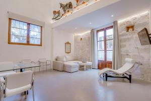 een woonkamer met witte meubels en een stenen muur bij Vintage Palma Palace Apartments TI in Palma de Mallorca