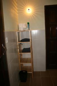 a bathroom with a shelf with towels and a light at Balai Serama Guesthouse in Kuala Tahan