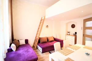 a living room with a purple couch and a ladder at Apartment on Masaryka 39 in Karlovy Vary