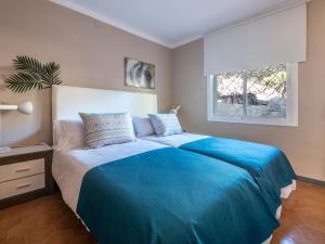 een slaapkamer met een groot blauw bed en een raam bij TarracoHomes-TH123 Apartment with sea view terrace in Cala Romana in Tarragona