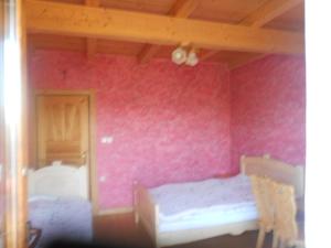 a bedroom with a pink wall with a bed in it at Gospodarstwo Karolina in Huba