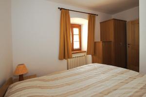 sypialnia z dużym łóżkiem i oknem w obiekcie Apartments Janks w mieście Vremski Britof