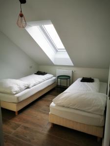 two beds in a room with a skylight at Sissi Apartments in Achau