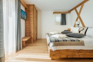 a bedroom with a wooden bed with pillows on it at Camina Suite and Spa in Cortina dʼAmpezzo