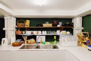 a kitchen with a sink and some baskets and dishes at Barn Laos Hostel in Vientiane