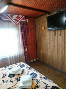 a bedroom with a bed and a tv on the wall at Гостинний Двір in Lviv