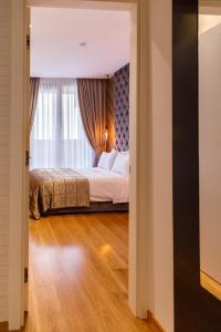 a bedroom with a bed and a window at Dali Apartments Pupin Palace in Novi Sad