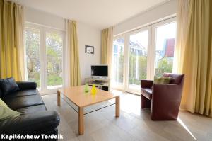 - un salon avec un canapé et une table basse dans l'établissement Kapitänshaus Tordalk mit 3 Schlafzimmern, à Norderney