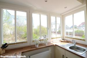 uma cozinha com 4 janelas e um lavatório em Kapitänshaus Tordalk mit 3 Schlafzimmern em Norderney