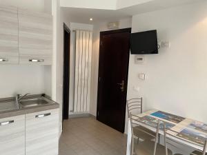 a kitchen with a sink and a table and a television at L'ancora di Monterosso - Cinque Terre in Monterosso al Mare