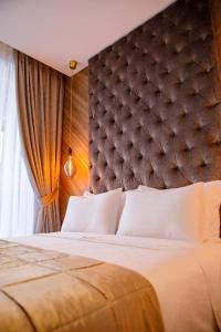 a bedroom with a large bed with a large headboard at Dali Apartments Pupin Palace in Novi Sad
