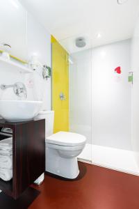 ein Badezimmer mit einem weißen WC und einem Waschbecken in der Unterkunft Qbic Amsterdam WTC in Amsterdam