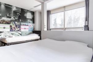 a bedroom with two beds and a window at Qbic Amsterdam WTC in Amsterdam