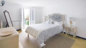 a white bedroom with a bed and a table at Villa Maria in Sintra