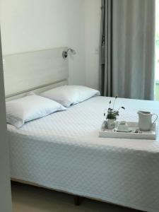 a bed with a tray with two cups and two mugs at Praia de Mariscal a 50 metros do mar in Bombinhas