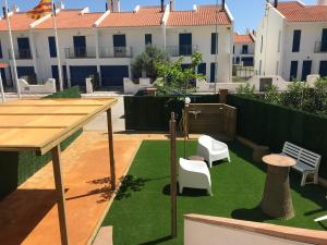 eine Terrasse mit Tisch und Stühlen und Gras in der Unterkunft Mas Pinell Viu bé in Torroella de Montgrí