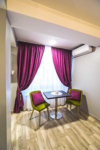 een kamer met een tafel, 2 stoelen en een raam bij Holiday Apartments in Galaţi