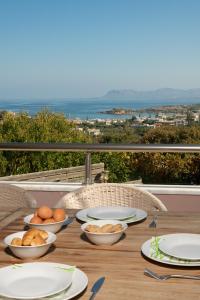 una mesa de madera con platos de comida en el balcón en Villa Stefania, en Kato Galatas