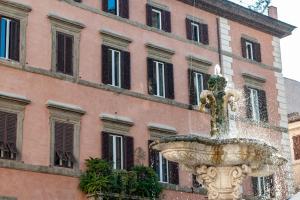 uma fonte em frente a um edifício rosa em Navona Jacuzzi Rooms em Roma