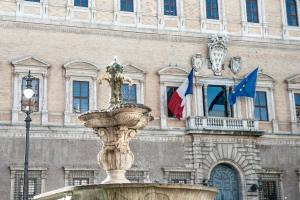 a fountain in front of a building with flags at Navona Jacuzzi Rooms in Rome