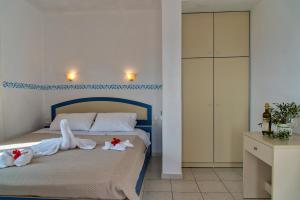 a bedroom with a bed with towels on it at Castri Village Hotel in Palekastron
