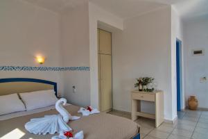 a bedroom with a bed with a swan on it at Castri Village Hotel in Palekastron