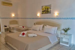 a bedroom with two beds with towels on them at Castri Village Hotel in Palekastron