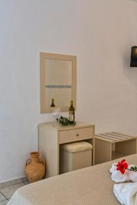 a bedroom with a bed and a mirror and a table at Castri Village Hotel in Palekastron