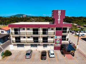 un edificio con coches estacionados en un estacionamiento en Hotel Rochamar, en Penha